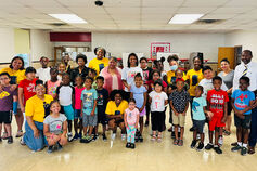 A group portrait of elementary school children, IU students, and teachers in a classroom.